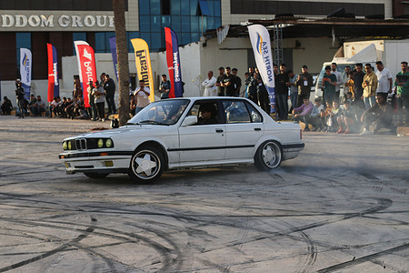 A professional drift his car in the middle of a track during a car drifting event. Young Libyans who are fond of cars love drifting, but they used to practice it without controls and an appropriate field for it. However, the Libyan International Automechanic Carnival gives them the opportunity to meet the famous people drifting in this sport and receive lessons and experiences with them.