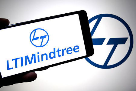 In this photo illustration, a LTI Mindtree logo is seen displayed on a smartphone with a L & T (Larsen & Toubro) logo in the background.