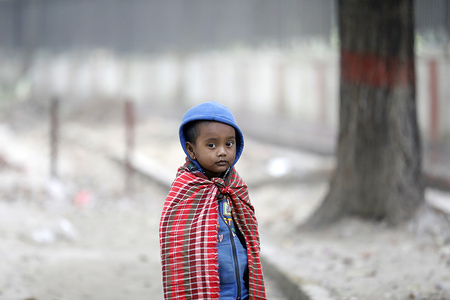 A kid poses for a photo during the cold weather in Dhaka.
The colds wave continues to disrupt life across the country in Bangladesh.