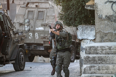 Israeli soldiers fire tear gas canisters at Palestinians during the withdrawal after demolishing two Palestinian houses in the village of Rumaneh near Jenin in the occupied West Bank. The Israeli army forces demolished the homes of Palestinians detained in Israeli prisons, Sobhi Sbeihat, 29, and Hassan Al-Rifai, 19, who were suspected of killing three Israelis in the Israeli town of Elad.