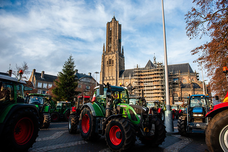 Hundreds of tractors exit from the provincial office during the demonstration.
Hundreds of farmers on tractors gathered all over the country, as they continued their protests against government efforts to cut back on nitrogen compound pollution as well as low supermarket food prices. In Arnhem around 400 farmers gathered with their tractors in front of the provincial government office, they also counted with the presence of German farmers supporting the actions around the country. There was a high police presence, not just Dutch but also German police.