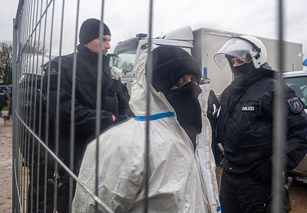 Hard-core climate activists are escorted to temporary dentition center to be charged, during today’s eviction and security clamp-down in Lutzerath. Lutzerath, has had a makeshift village occupied by climate activists for the better part of two-years. All came to an abrupt end this week, as police arrived in-mass totaling 1000 to dismantle, arrest and evict the village occupiers from the settlement they refer to as ‘Utopia’. All entry points leading to and from the village were manned by checkpoints. The settlement consists of makeshift homes, built from discarded recycled building material, some with solar panels and some structures measuring meters in height, also- platforms and tree-houses secured to the tree canopy. The complex has one main building as a community food and hygiene area, this was to be one of the last strongholds. Today, the building housed on the whole a group of very peaceful activist. A very small minority occupying central wing of the complex, threw stones, bottles, fireworks and apples at the police!