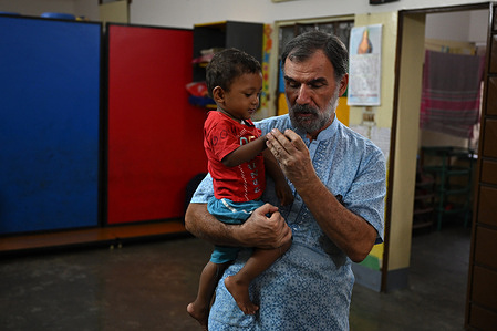 Children of the Mamata Day Care center seen playing with Fr. Gian Paolo 
Gualzetti (PIME).