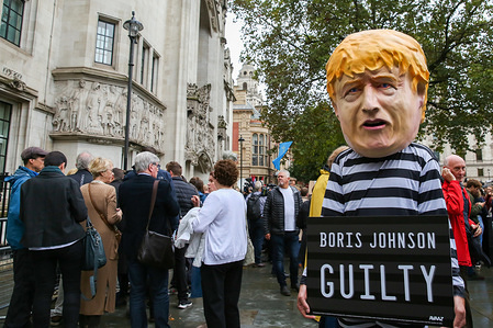 A protester wearing a prisoner's outfit and British Prime Minister Boris Johnson's face mask outside The Supreme Court on the day the court ruled that the British Prime Minister Boris Johnson's decision to prorogue Parliament is unlawful.