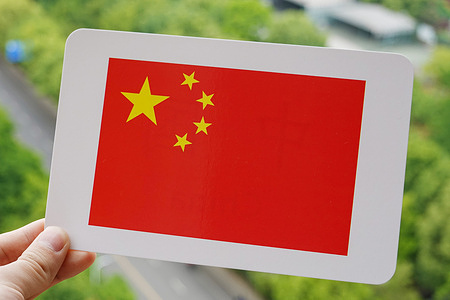 In this photo illustration, China's national flag is printed on a white card.
