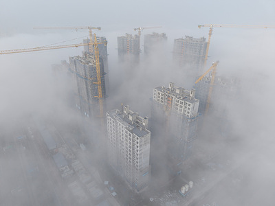 (EDITOR'S NOTE: Image taken with drone)
A construction site with cranes and buildings under construction is obscured by dense fog