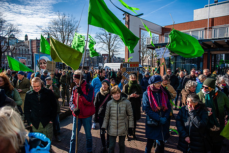 Protesters seen holding green flags while listening to speeches in front of the city hall, during the demonstration.
In order to prevent the disappearance of Amsterdam's urban nature, more than 40 ecological residents' organizations, joined forces and together they are proclaiming the 'Green Revolution of Amsterdam'. After seeing a selection of plans of municipality to destroy several green areas in the city, with the construction of parking garages, place wind turbines in vulnerable bird areas, etc, the organizations held a demonstration in the city center in front of Stopera, where the town hall is located to send an urgent signal to the Amsterdam city council to stop these plans.