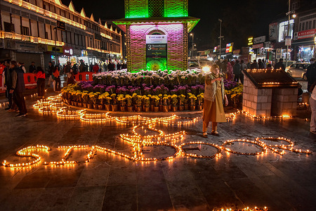 A police woman stands guard near the oil lamps on the occasion of Diwali, the Hindu festival of lights. Deepavali, also known as Diwali or the Festival of Lights, is a major Hindu festival celebrated worldwide between mid-October and mid-November. The festival symbolizes the victory of light over darkness and good over evil, marked by lighting lamps, exchanging sweets, and performing prayers for prosperity. Spanning five days, it includes rituals such as Dhanteras, Choti Diwali, Lakshmi Puja, Govardhan Puja, and Bhai Dooj, each celebrating themes of renewal, victory, and family bonds.