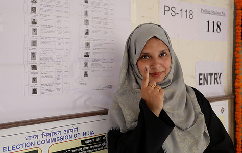 A Muslim Woman Voter shows her finger marked with indelible ink after casting her vote at a polling station during the sixth phase of Lok Sabha elections.