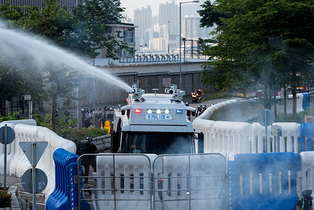 A riot control vehicle fires a liquid solution at protesters during the demonstration.
Thousands of protesters marched through the streets on the 15th continuous week of unrest. While the demonstration began peacefully, protesters later faced off against police in front of government offices. Protesters threw bricks and petrol bombs while police attempted to keep the demonstrators at bay by firing dozens of tear gas rounds and blunt projectiles. Riot police eventually deployed vehicles equipped with water cannons and conducted a full dispersal operation. Protesters continue to fight for the remaining four demands after the extradition bill was formally withdrawn the previous week.