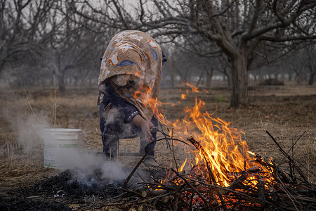 A Kashmiri woman burns twigs of apple trees to make charcoal on a cold winter day. The charcoal known locally as “czinne” is an essential ingredient for the traditional Kashmiri firepot called the “kangri” which people use to stay warm during harsh winter months.