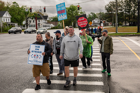 Machinist union workers march with placards expressing their opinion during a strike over failed negotiations with Pratt & Whitney. Thousands of Pratt & Whitney machinists strike after contract negotiations failed regarding wages, job security, and benefits.