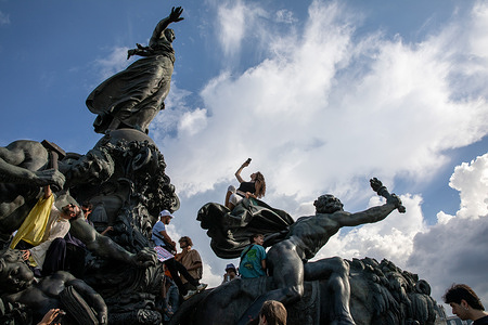 A women poses on the La Triomphe De La Republique statue during the Labour Day demonstration. On May 1, 2026, the annual Labour Day march took place through Paris, drawing large crowds of demonstrators. While most marched peacefully, some groups clashed with police along the route. Officers used tear gas to disperse crowds after objects were thrown, and several streets were temporarily blocked. The events reflected ongoing tensions during public demonstrations.