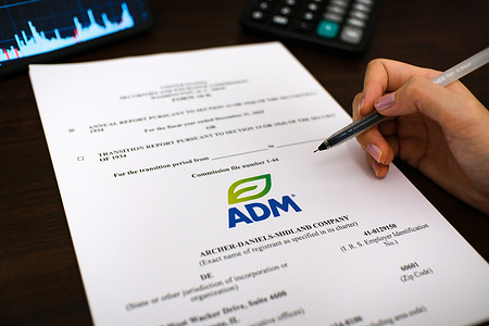In this photo illustration, a woman is reviewing the Form 10-K annual report of Archer-Daniels-Midland Company for the fiscal year ended December 31, 2025.