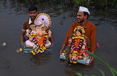 Devotees carry idols of elephant-headed Hindu god Ganesha (L) and goddess Gauri (R) (mother of elephant-headed Hindu god Ganesha) to immerse in a stream of free flowing water at a village in Raigad district on the outskirts of Mumbai. Idol immersions continue across Mumbai on September 19, as families and smaller community groups observe scheduled 6th-day and 7th-day Visarjan ceremonies. These rolling immersions lead up to Anant Chaturdashi on September 25, when the ten-day Ganesh Chaturthi festival officially concludes with the final, large-scale public processions.