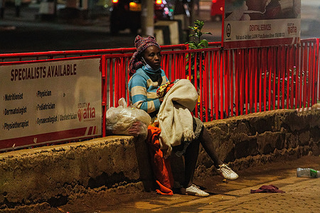 A homeless Kenyan lady holding her baby as she ponders her next move as the new 8pm-4am curfew takes effects.On Friday, March 26th, President Uhuru Kenyatta announced a partial lockdown and instituted new curfew measures to start from 8pm to 4am. The new measures to curb the spread of COVID-19 include placing Nairobi, Nakuru, Kiambu and Machakos counties under partial lockdown as well as closing restaurants, bars and schools nationwide amid a third wave of COVID-19 across the country.