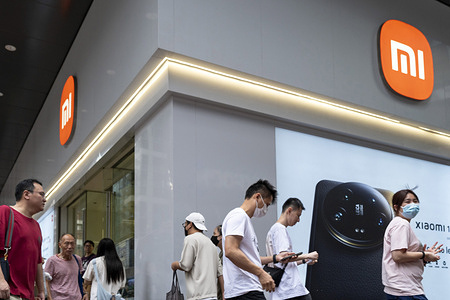Pedestrians walk past the Chinese multinational technology and electronics brand Xiaomi flagship store in Hong Kong.