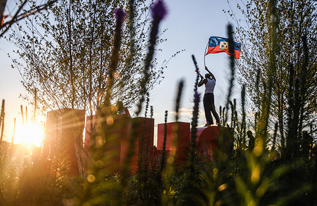 A supporter of the Haiti national football team waves a flag atop a statue ahead of the 2026 FIFA World Cup Group C match between Haiti and Brazil at Lincoln Financial Field in Philadelphia. Fans of the Brazil and Haiti teams gathered outside Lincoln Financial Field in Philadelphia to tailgate and attend watch parties. Final score: Brazil 3-1 Haiti.