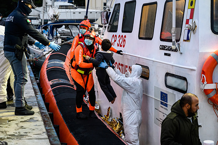 Italian Coast Guard crews help a child to disembark from a rescue boat at the Roccella Harbour.
Nearly 200 migrants composed of women and children were rescued by the Italian Coast Guard. The migrants were brought to Roccella Jonica, a town located on the Ionian Sea in Calabria. Upon arriving, Red Cross and Civil Protection were provided sanitary help while authorities carried out the identification process.