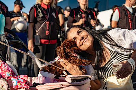 A woman is at the protest site with her dog. Animal rights activists gathered outside the Izmir Governor's Office to protest the implementation of Turkey's law on stray animals and local authorities' efforts to round up stray dogs. Police blocked access to the governor's office with barricades, preventing demonstrators from reaching the building. Protesters then staged a sit-in, calling for an end to the roundup of stray animals and condemning what they described as poor conditions and inhumane treatment in municipal shelters.