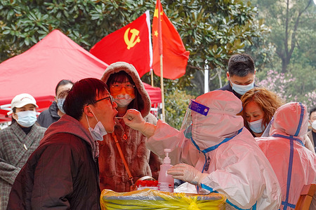 A medical worker takes a swab sample from a man for nucleic acid test at a COVID-19 testing site in Xinbei District of Changzhou. In order to control the spread of COVID-19 as soon as possible, the Changzhou municipal government has decided to close down all businesses except in Liyang and Jintan districts from March 19 to 24, and all residents will be tested for COVID-19.