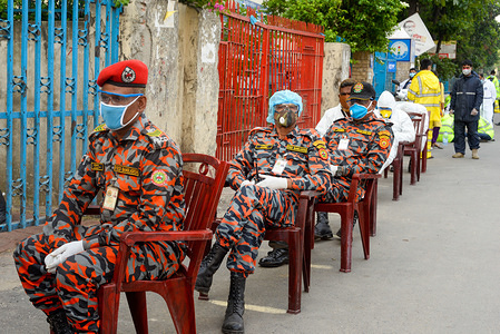 Members of Bangladesh fire brigade wearing face masks as a precaution while waiting in queue for the test.Bangabandhu Sheikh Mujib Medical University is being used to conduct covid-19 tests as countries around the world are taking increased measures to stem the widespread of the SARS-CoV-2 coronavirus which causes the COVID-19 disease.