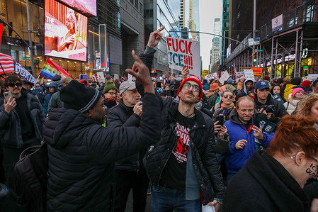 (EDITORS NOTE: Image contains profanity) Protesters give the middle finger while dancing to a song called “Fuck Trump”, in Time Square, Manhattan. Thousands of New Yorkers protested between Central Park and Times Square, opposing the murders committed by ICE and in memory of the death of Renee Nicole Good.