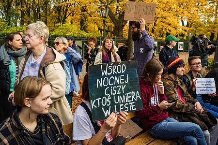 A protester covers her face with a placard written in Polish that says "In the silence of the night, someone dies in the forest", referencing the situation on the Polish/Belarussian border during the rally. A coalition of activist groups protested against the Polish government's plan to suspend the right to asylum, which they argue is a fundamental human right. On October 15, the government announced a new migration strategy for 2025-2030 that includes a "temporary and territorial suspension" of asylum applications, intended to address the Polish-Belarusian border crisis. Protesters claim this violates Article 56 of the Polish Constitution and international agreements. They marched through Warsaw, condemning the political exploitation of the refugee crisis.