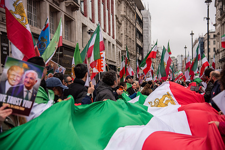 Protestors march with a large Iranian flag in support of changing Iran's regime. Many Iranians seek a new regime and protest to secure fundamental human rights, economic stability, and social freedoms that have been suppressed under decades of restrictive clerical rule.