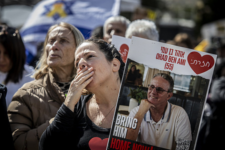 An Israelis woman holds a placard of Ohad Ben Ami as others watch the release of hostages from the Gaza Strip at hostages square. Three male Israeli hostages and 183 Palestinian prisoners were freed in the fifth round of exchanges between Israel and Hamas as Israel expressed concern about the appearance of the released captives. Ohad Ben Ami, Eli Sharabi, and Or Levy all taken hostage during the Hamas-led October 7 attack on Israel were handed to the Red Cross in the central city of Deir al-Balah on day 491 of their captivity in Gaza.