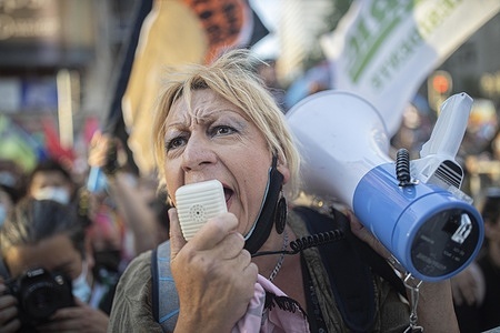 A supporter of Gabriel Boric, the candidate elected as the future President of Chile, speaks on a megaphone as supporters celebrate his victory at the center of the Chilean capital.