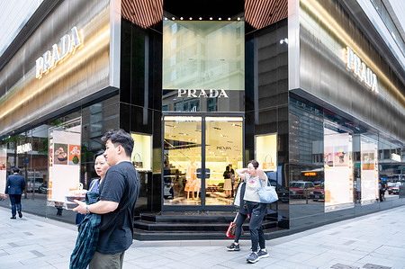 Pedestrians walk past the Italian luxury fashion company Prada store in Hong Kong.