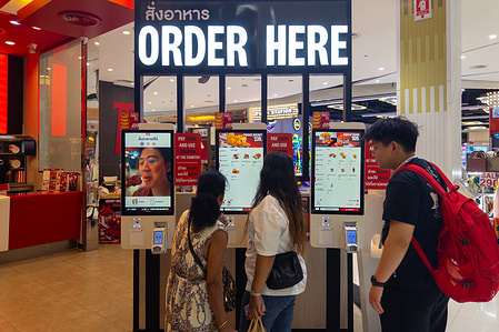 Diners are placing orders on devices in a KFC restaurant "Kentucky Fried Chicken" at Big C Supercenter Ratchadamri shopping mall.