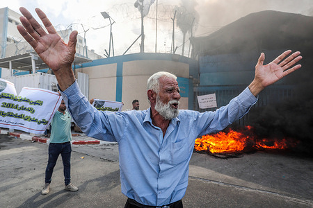 A protester chants slogans during the demonstration. The owners of houses which were destroyed during the Israeli war in 2014, burn tires and protest demanding for the reconstruction of their houses as they gather outside the Works Agency UNRWA (United Nations Relief and Works Agency for Palestine Refugees).