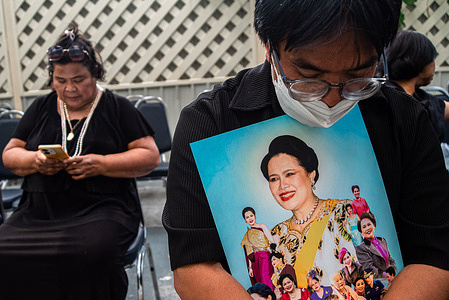 A man holds a portrait of Queen Mother Sirikit after the announcement of her death at the Chulalongkorn Hospital in Bangkok. The Queen Mother Sirikit died at the age of 93 on 24 October 2025 at the Chulalongkorn Hospital.