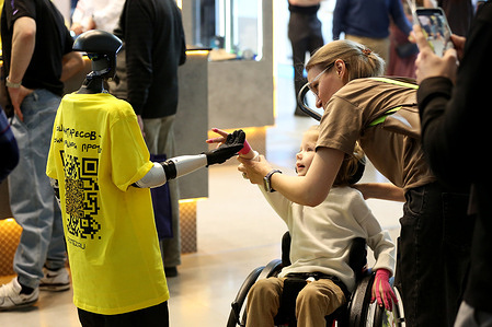 A visitor greeting bionic robot at the Russian Antares Group vendor booth during 10th International Exhibition of Equipment and Technology for Rehabilitation and Care Intergration Moscow is an international specialized exhibition of innovative technologies for social adaptation and rehabilitation of people with disabilities, limited health and developmental disabilities. The event brings together more than 4000 visitors from 7 countries and 144 exhibitors.