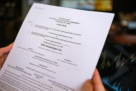 In this photo illustration, a woman is reviewing the Form 10-K annual report of Dell Technologies Inc. for the fiscal year ended January 30, 2026.