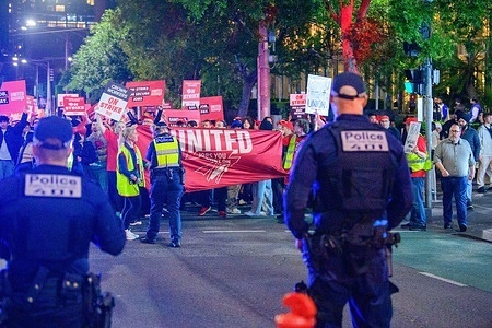Protesters gather with a banner and placards outside Crown Casino in Melbourne as Public Order Police monitor the situation. 400 union members took part in Industrial action outside Crown Casino on New Year’s Eve 2025. The members of the United Workers Union staged a strike and march over Crown unfair pay offer. The action formed part of an ongoing workplace dispute and coincided with one of Melbourne’s busiest nights of the year. Union members walked off the job at 10 pm and maintained a presence outside the casino as New Year’s Eve celebrations continued across the city.