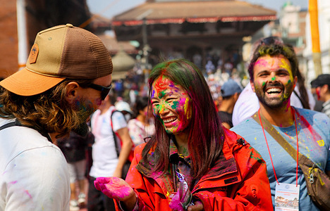 People smeared with vermilion powder take part during the Holi festival celebration. The Holi festival is celebrated to mark the victory of good over evil and also symbolizes the arrival of the spring season.
