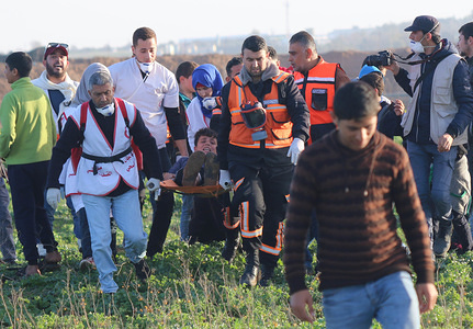 Medics are seen carrying a wounded person during the clashes between the Palestinian citizens and the Israel forces north of the Gaza Strip in protest against the recognition of US President Trump Jerusalem as the capital of Israel.