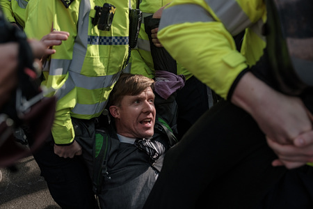 A protester is arrested by police officers during the Extinction Rebellion Strike in London.
Extinction Rebellion have blocked five central London landmarks for fourth day in protest against government inaction on climate change.