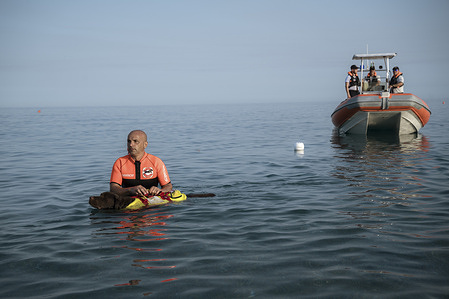 A rescuer with a rescue dog with the coast guard in the background. To mark World Drowning Prevention Day, several demonstrations of rescue and first aid operations were carried out by the local members of the Coast Guard, Red Cross, Army and dog units of the Italian School for Rescue Dogs (Scuola Italiana Cani Salvataggio -Sics).The demonstration took place in the Catanzaro Lido on Coco Beach on the coast of Catanzaro.