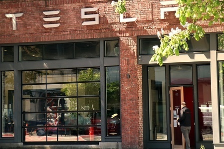 A man enters the showroom of a Tesla dealership.
Tesla announced its Q1 2021 earnings today.