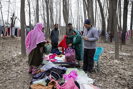 Kashmiri people buy warm clothes on a cold and foggy winter day in Pulwama, south of capital city Srinagar. The region is experiencing an intense spell of winter, with mercury levels slipping below freezing and the mornings coated in frost as cold winds sweep through the valley.