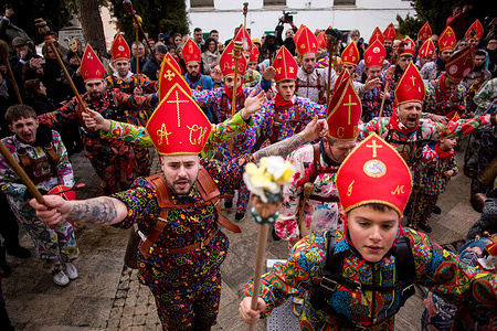 Members of the Endiablada brotherhood jump with open arms in front of the procession of the image of Saint Blaise, during the festival of "La Endiablada," in honor of the Virgin of Candelaria and Saint Blaise of Sebaste, in the Spanish town of Almonacid del Marquesado. La Endiablada is possibly one of the oldest traditional celebrations in Spain, where men (known as the Devils), dressed in colorful costumes and with cowbells on their waists, roam the streets of the town jumping, dancing, and carry the statue of the Saint in procession. Celebrated in honor of the Virgin of Candelaria and Saint Blaise of Sebaste, La Endiablada is considered one of Spain’s oldest traditional festivals. During the event, men known as “the Devils,” dressed in colorful costumes with cowbells around their waists, jump and dance through the streets while carrying the statue of the saint in a lively procession.