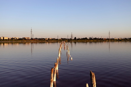 A woman relaxes in the warm water near the destroyed wooden pier of The Kuialnyk Estuary. The Kuialnyk Estuary formerly known as Andriivskyi Lyman, is an estuary of the Velykyi Kuialnyk on the northwest coast of the Black Sea, one of the group of Odesa estuaries, located north of Odesa. On the southeast coast of the estuary there is the Kuialnytskyi mud resort, on the banks of the estuary beaches. The water level in the estuary and its salinity are regularly changed. In recent years the estuary has been rapidly become shallow.