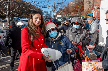 New York State Assembly member Jenifer Rajkumar hands out free Thanksgiving as hundreds of New Yorkers wait in line during the annual free Thanksgiving Turkey Giveaway event at her District Office in the Woodhaven neighborhood of Queens borough in New York City.