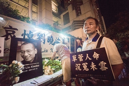 A man seen holding a plea card for Liu Xioabo. Residents of Hong Kong hosted a vigil service outside the Chinese Liaison Office of Hong Kong after the death of Human Right Activist and Nobel Peace Prize Winner Liu Xiaobo. Liu Xiaobo has been in prison by the Chinese authority since 2008 for charges made against him for "suspicion of inciting subversion of state power."