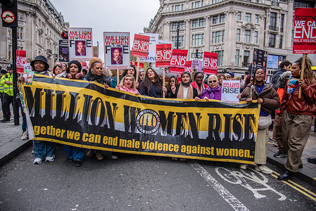 Female participants hold a large banner during the 19th Annual Million Women Rise March and Rally! We march in sisterhood, solidarity, and unity to protest the lack of action to address male violence. We march to remember, and grieve, the countless women and girls who have been killed through male violence, including through state inflicted / sanctioned abuse.