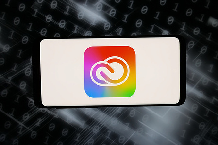 In this photo illustration, the logo of software product Adobe Creative Cloud is displayed on a smartphone in front of abstract background on computer screen.